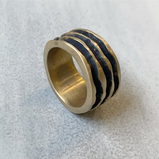 Gold textured ring on a grey surface 